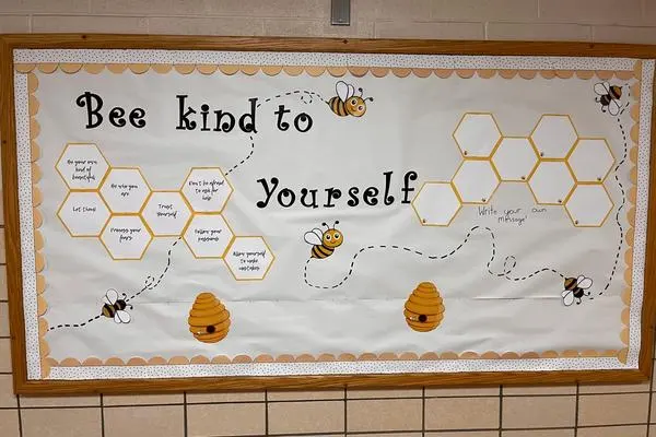 Bulletin board displayed in school hallway with slogan "Bee kind to yourself" and inside honeycombs are positive messages